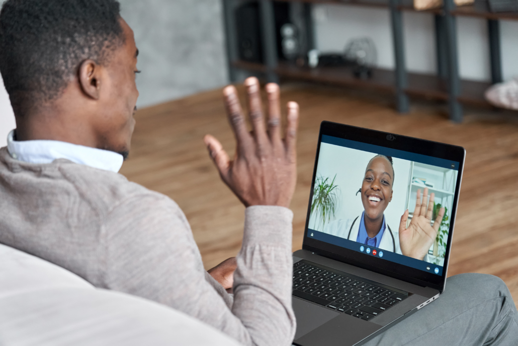 Male black patient talking on conference video call to female african doctor. Virtual therapist consulting young man during online appointment on laptop at home. Telemedicine chat, telehealth meeting for virtual healthcare interpretation