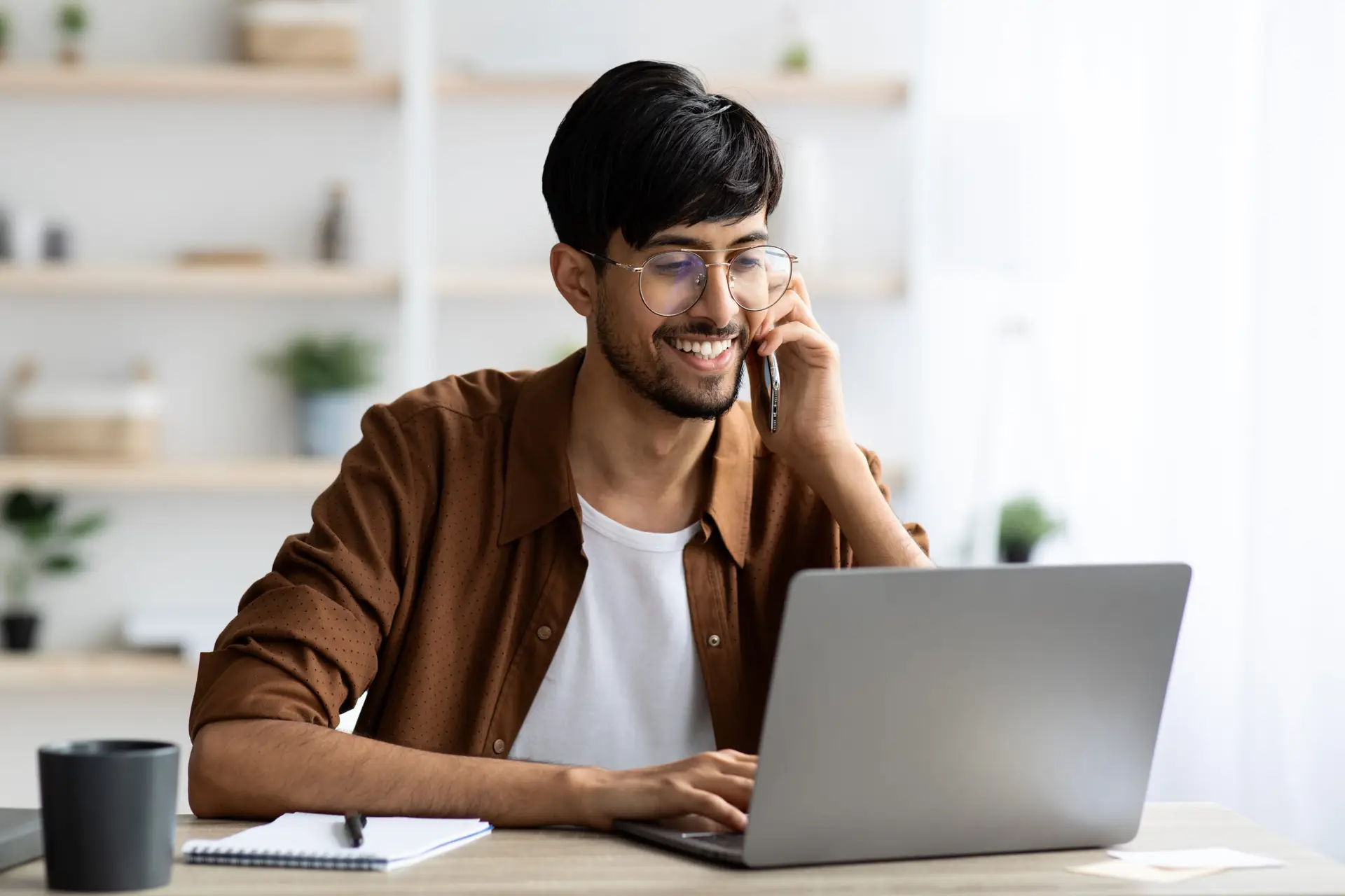 Cheerful indian guy businessman with laptop